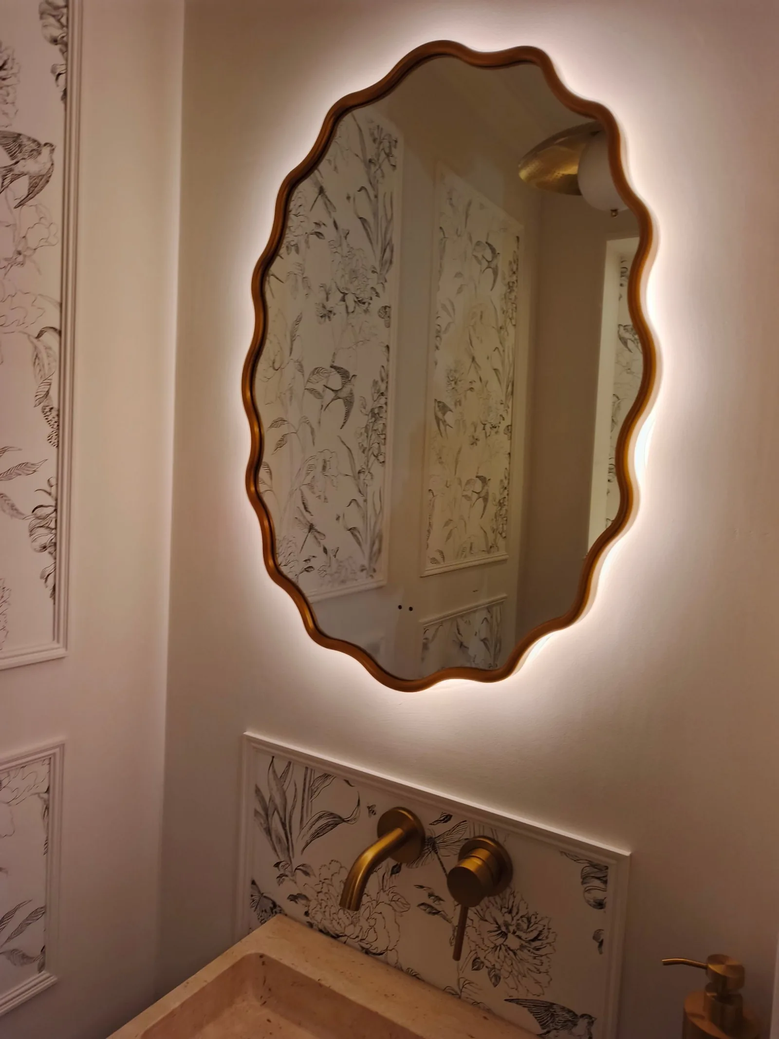 LED backlit mirror glowing against botanical wallpaper panels in a Poole BH14 cloakroom