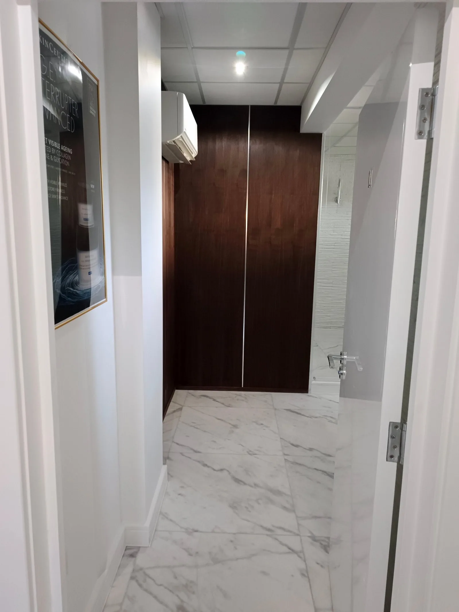 Marble-floored corridor and walnut panelling in a clinic in Lilliput, Poole BH14