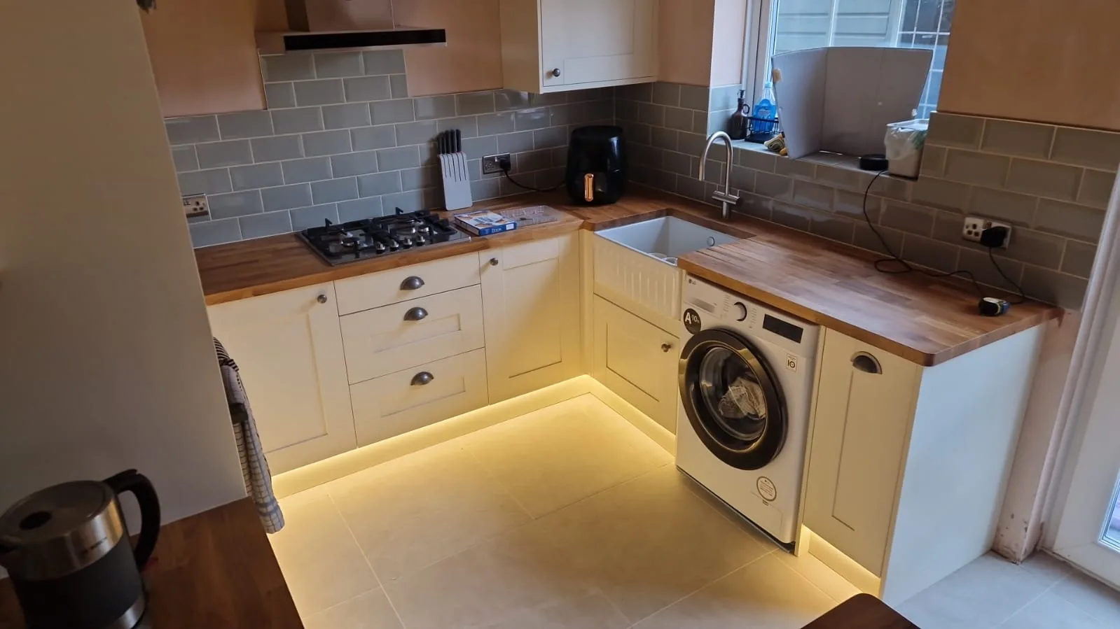 Warm white LED plinth lighting along cream shaker kitchen units in Winton, Bournemouth BH9