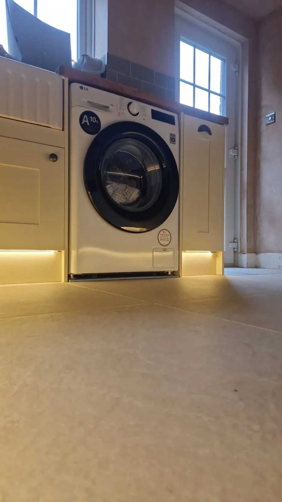 LED plinth lighting either side of the washing machine in a Winton, Bournemouth kitchen