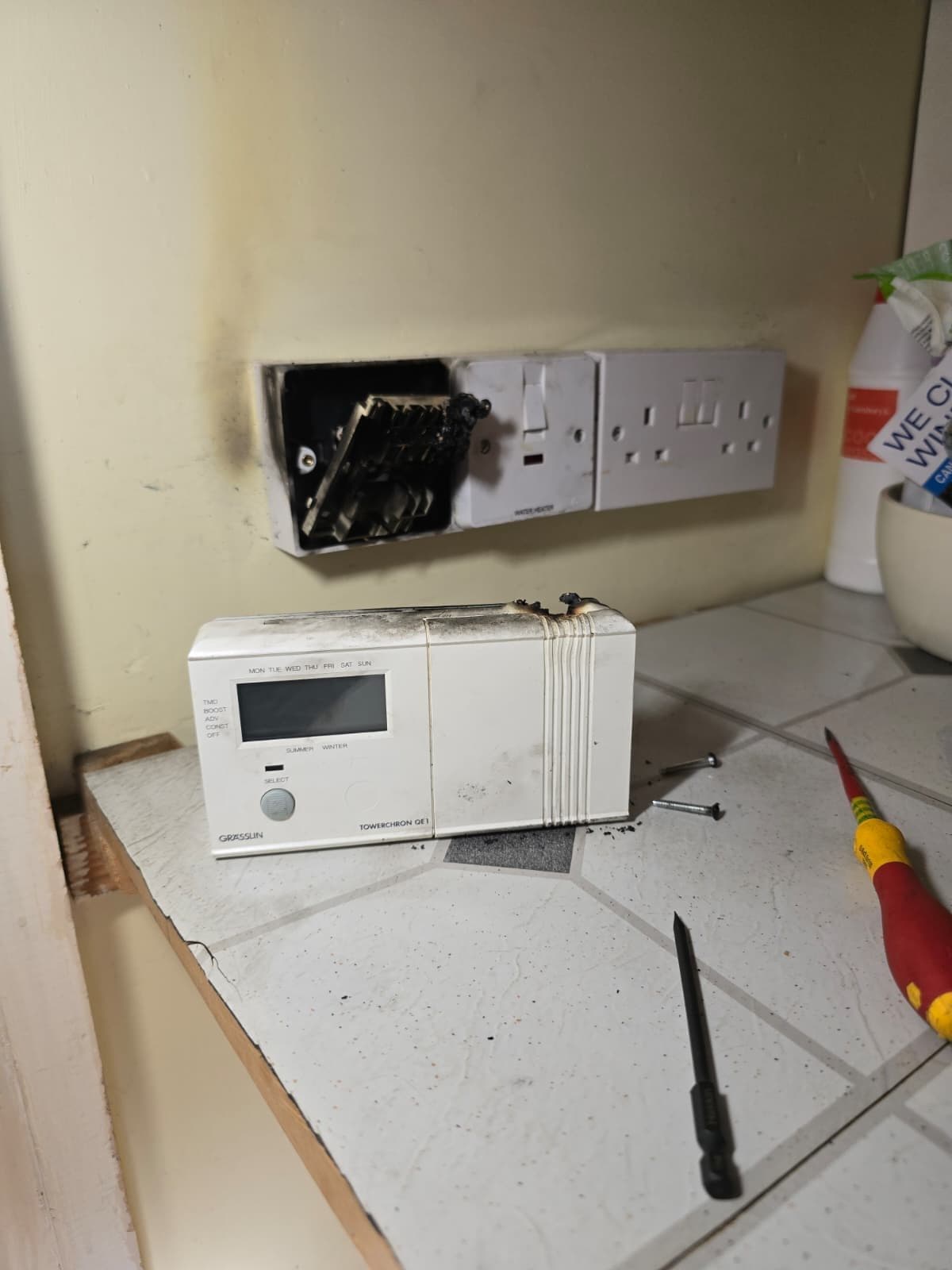 Burnt wood and black soot on the wall behind the heating programmer.